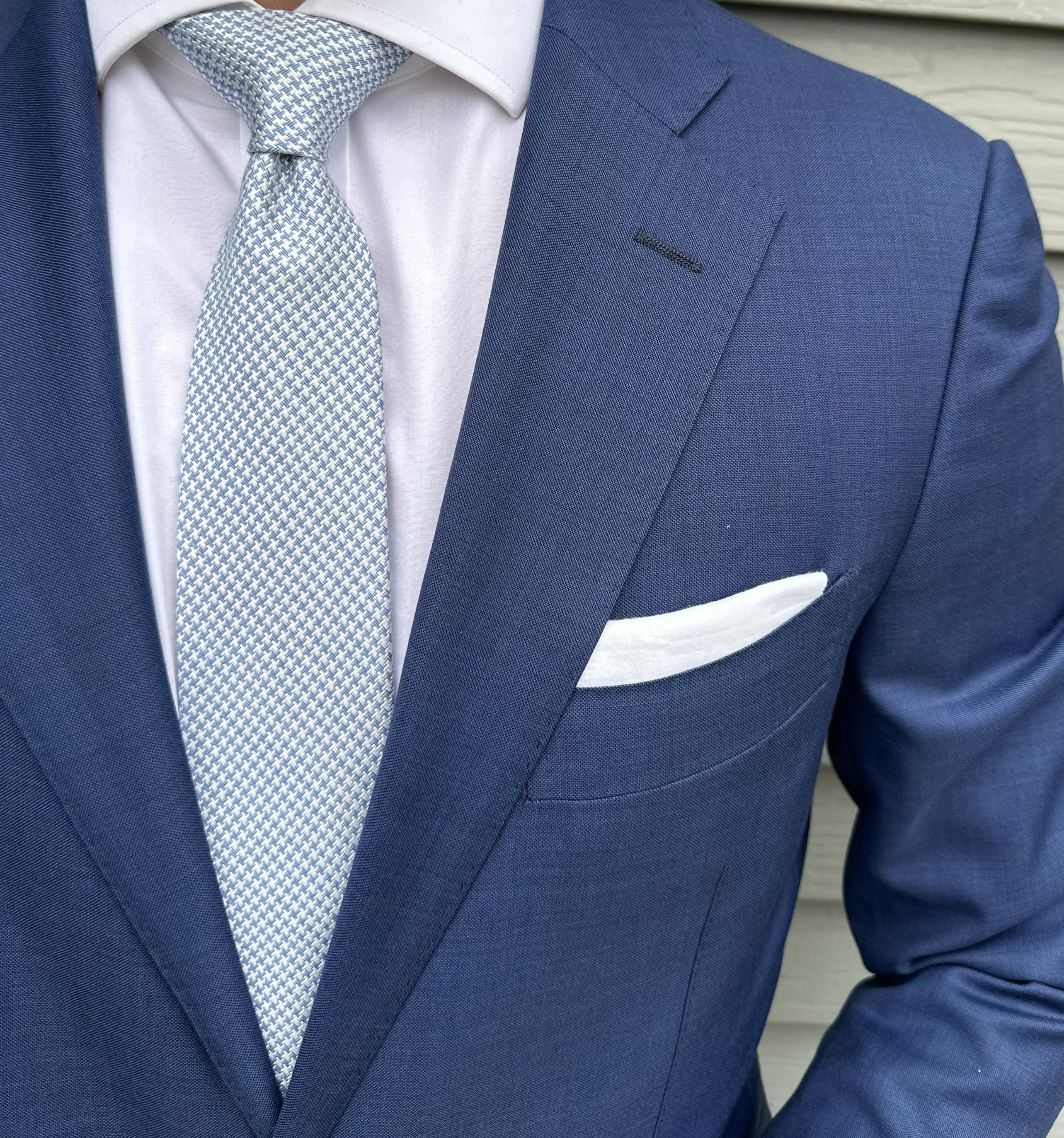 Blue houndstooth silk necktie shown close up, small-scale check weave