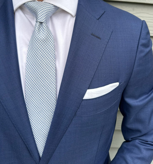 Blue houndstooth silk necktie shown close up, small-scale check weave