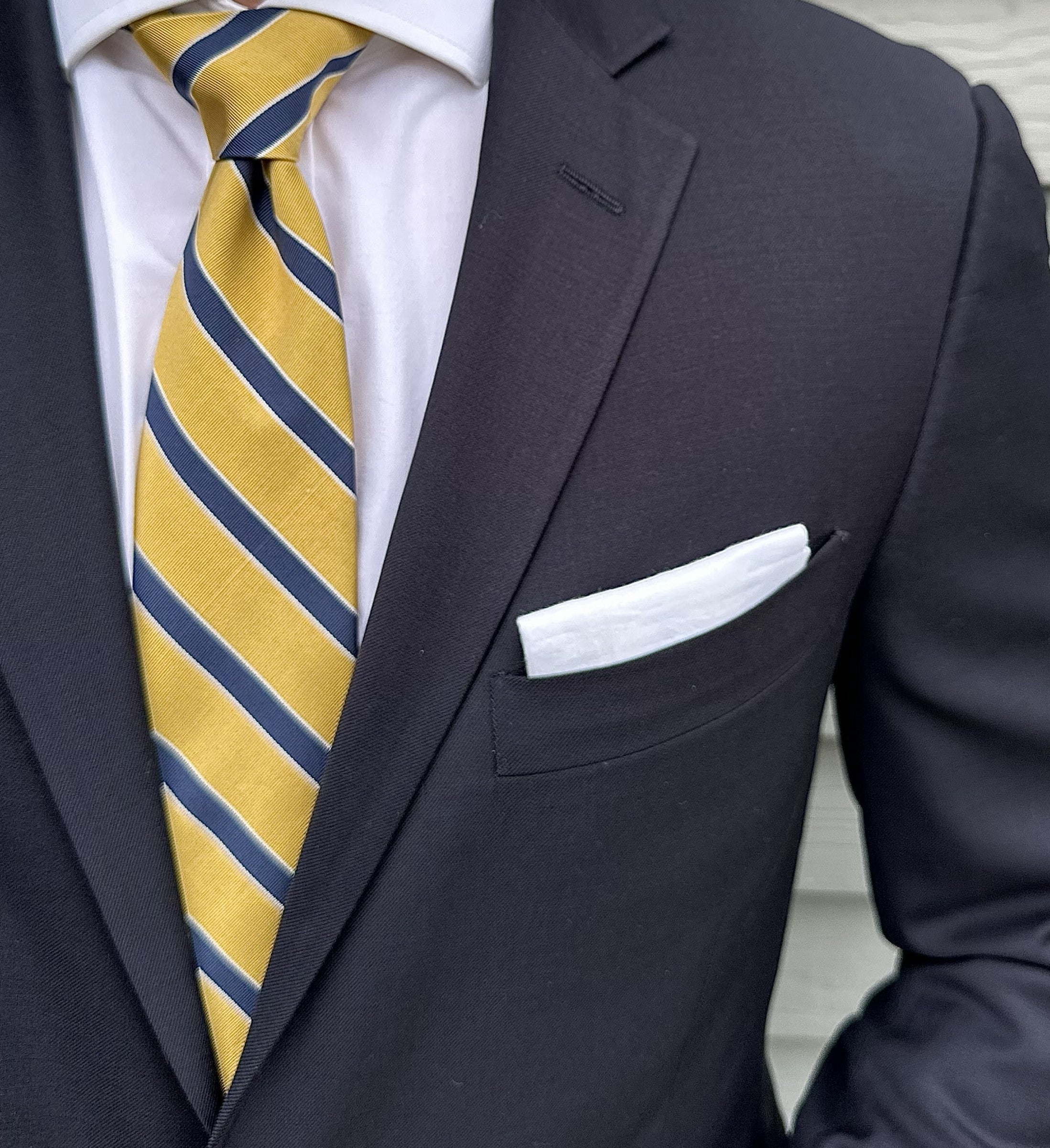 Yellow mogador striped necktie laid flat, matte woven surface visible