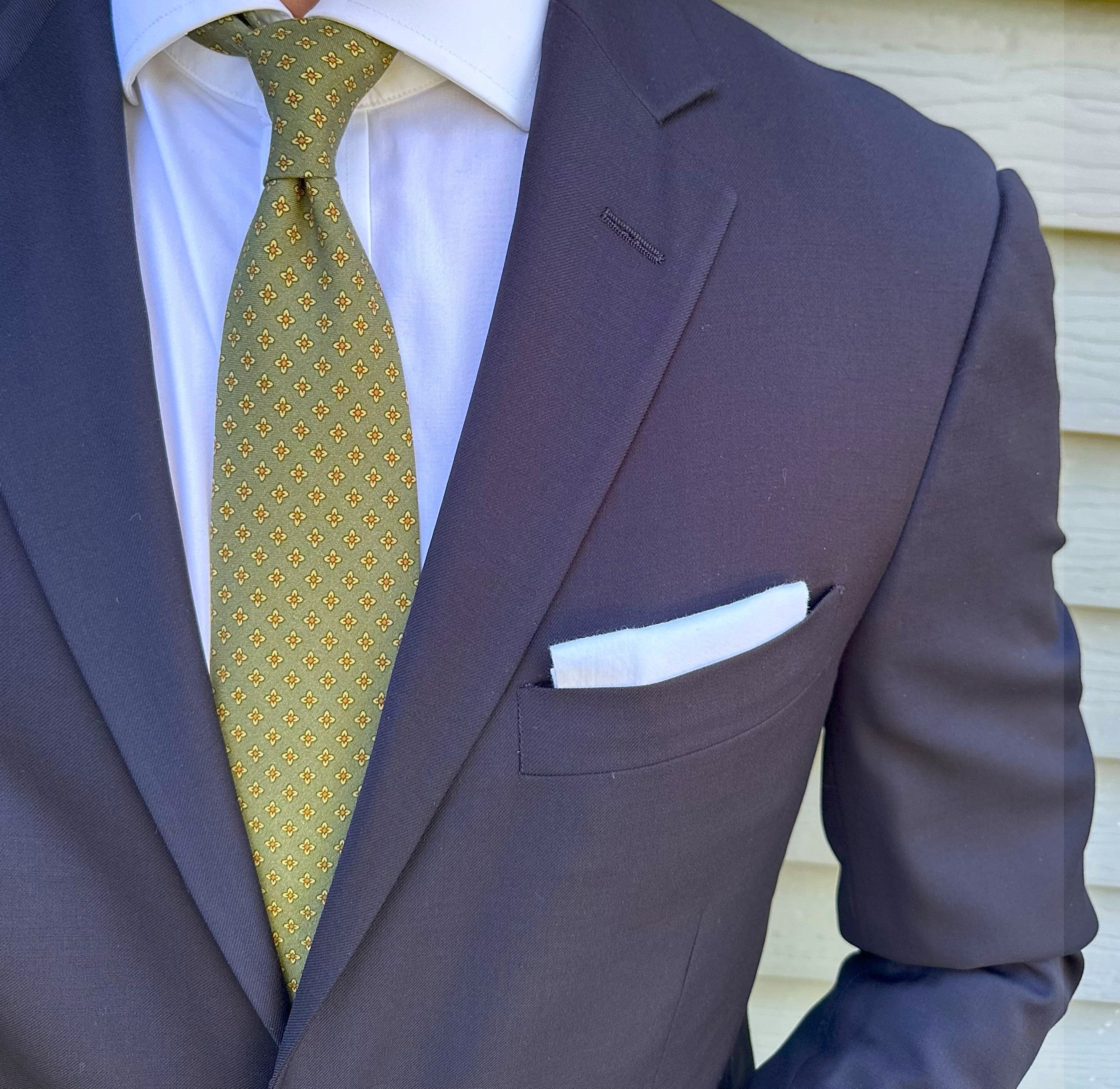 Moss green foulard silk necktie with a fine motif, photographed flat