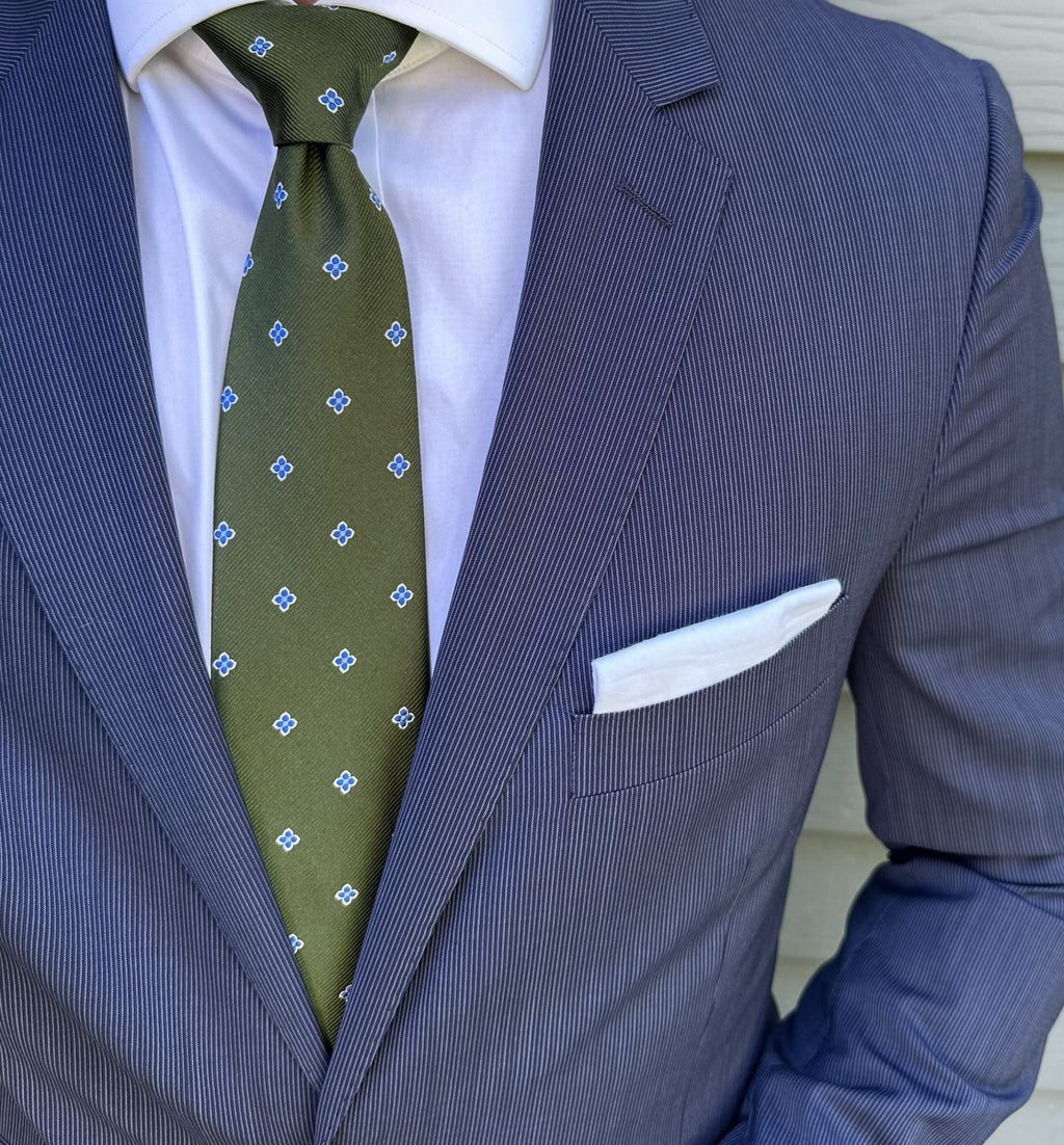 Green foulard silk necktie with a fine repeating pattern, laid flat
