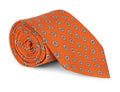 Orange foulard silk necktie with a fine repeating motif, shown flat
