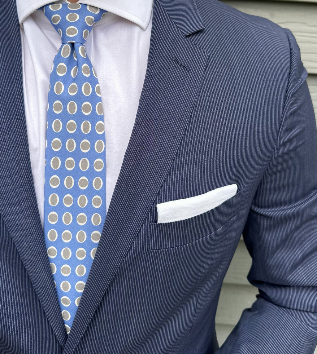 Blue silk necktie patterned with small repeating ovals, close detail