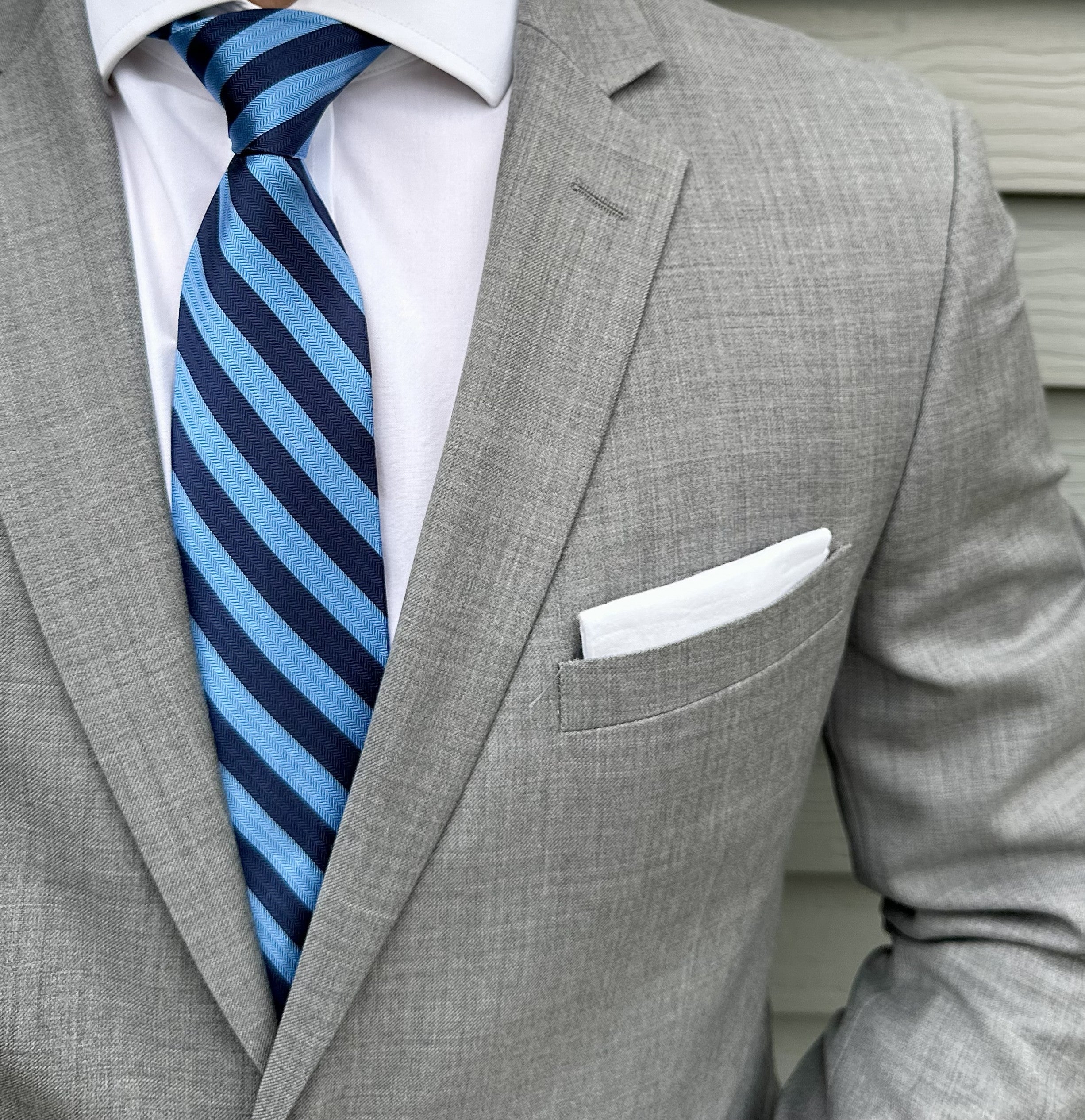 Blue striped silk necktie laid flat with the knot end in view