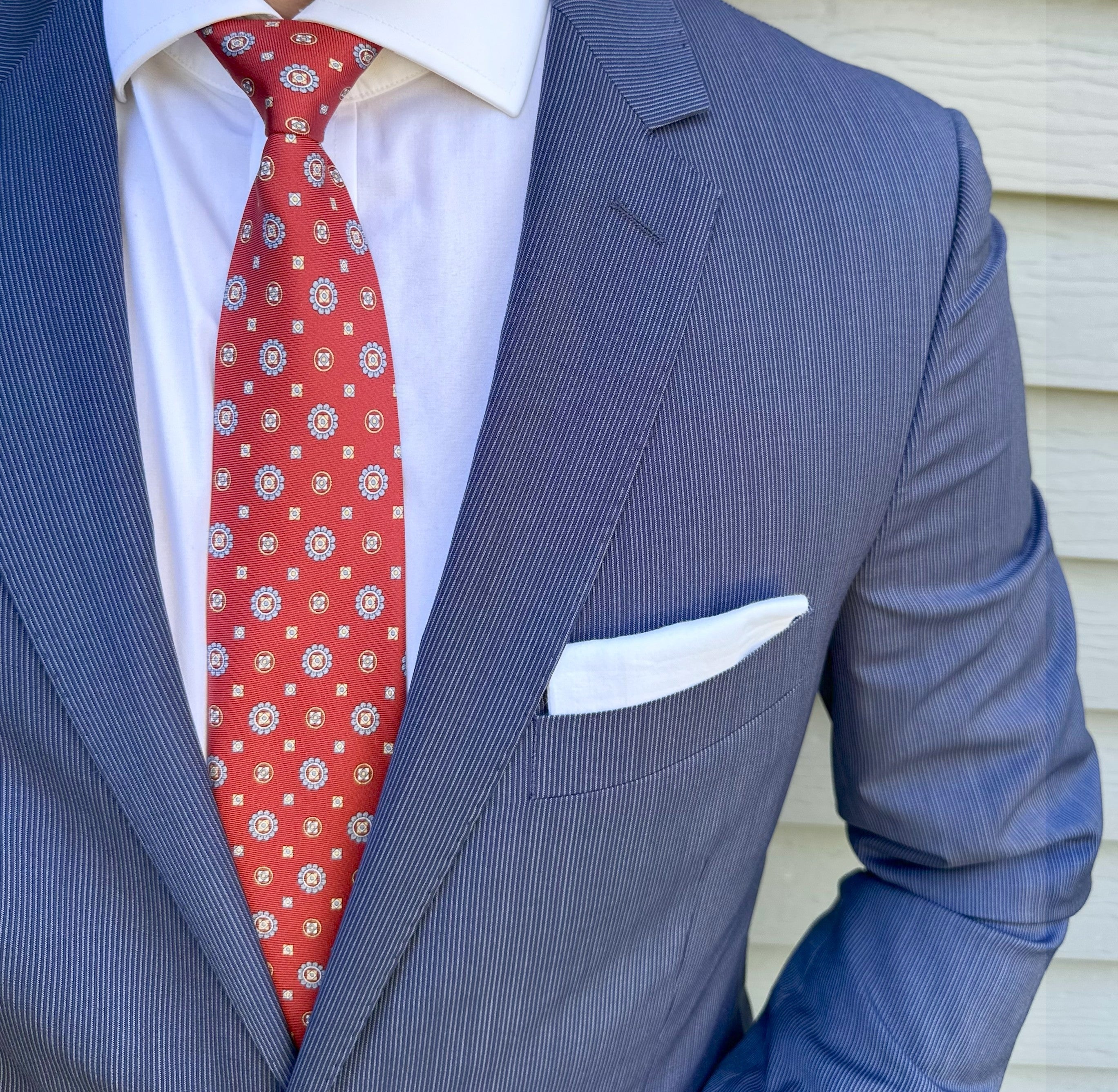 Vivid red foulard necktie printed in blue, gold and white on silk twill