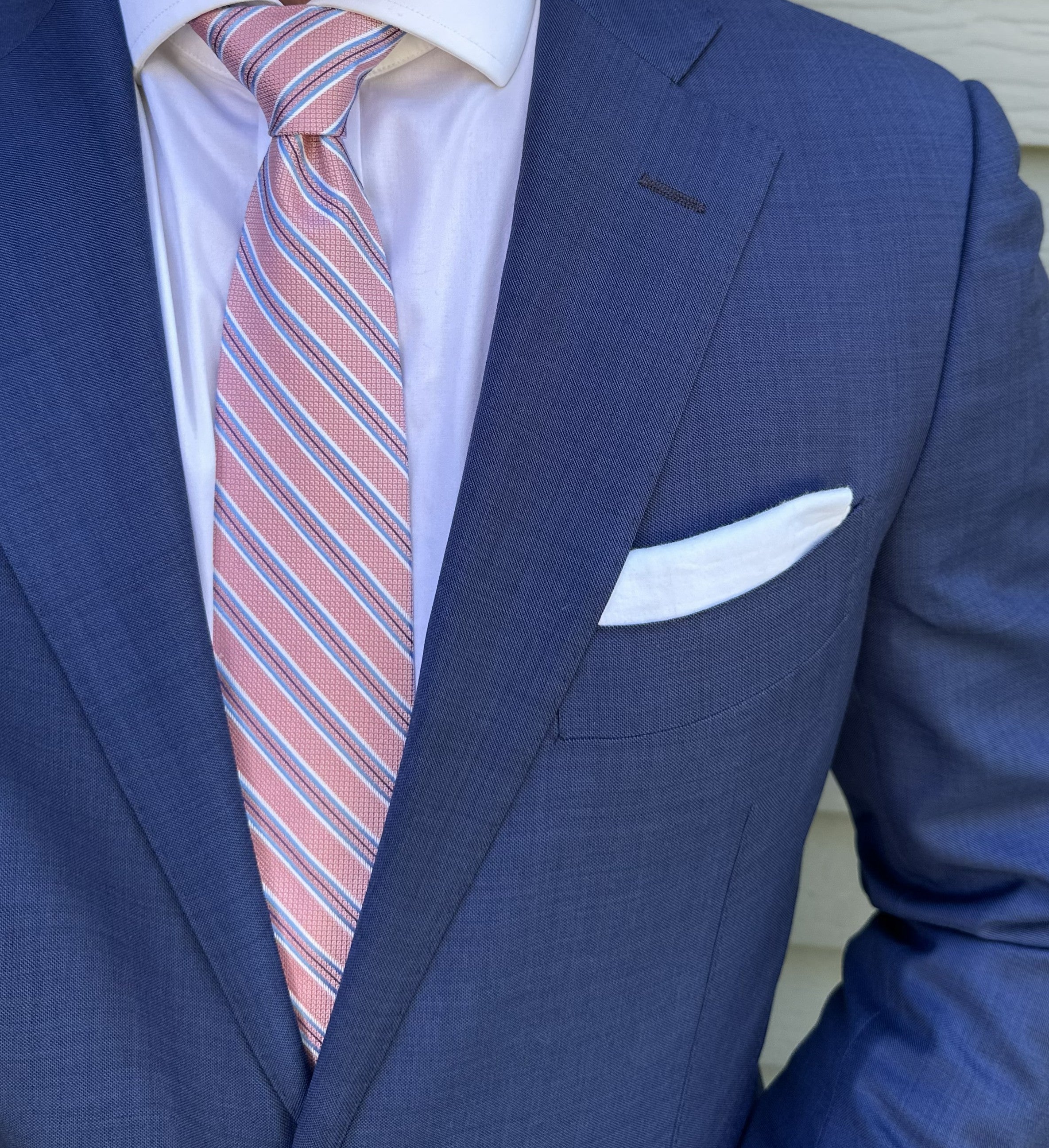 Pink and navy bar striped silk necktie laid flat, stripe repeat visible