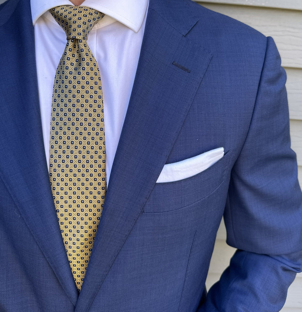 Gold silk necktie with a micro square pattern, shown in close detail