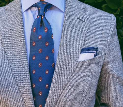 Ribbed weave texture behind medallion motifs on blue tie