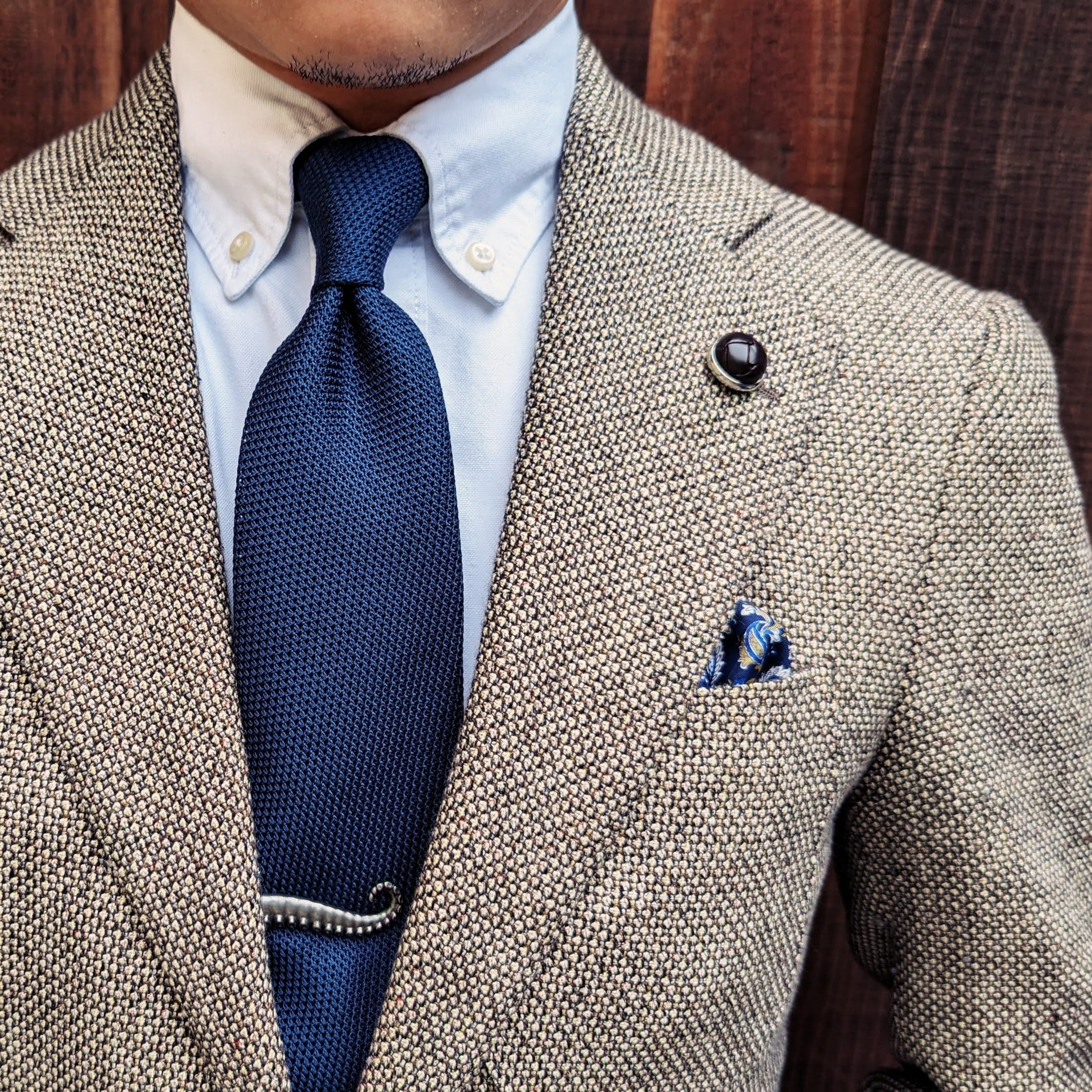 Navy grenadine silk necktie photographed flat, textured weave in detail
