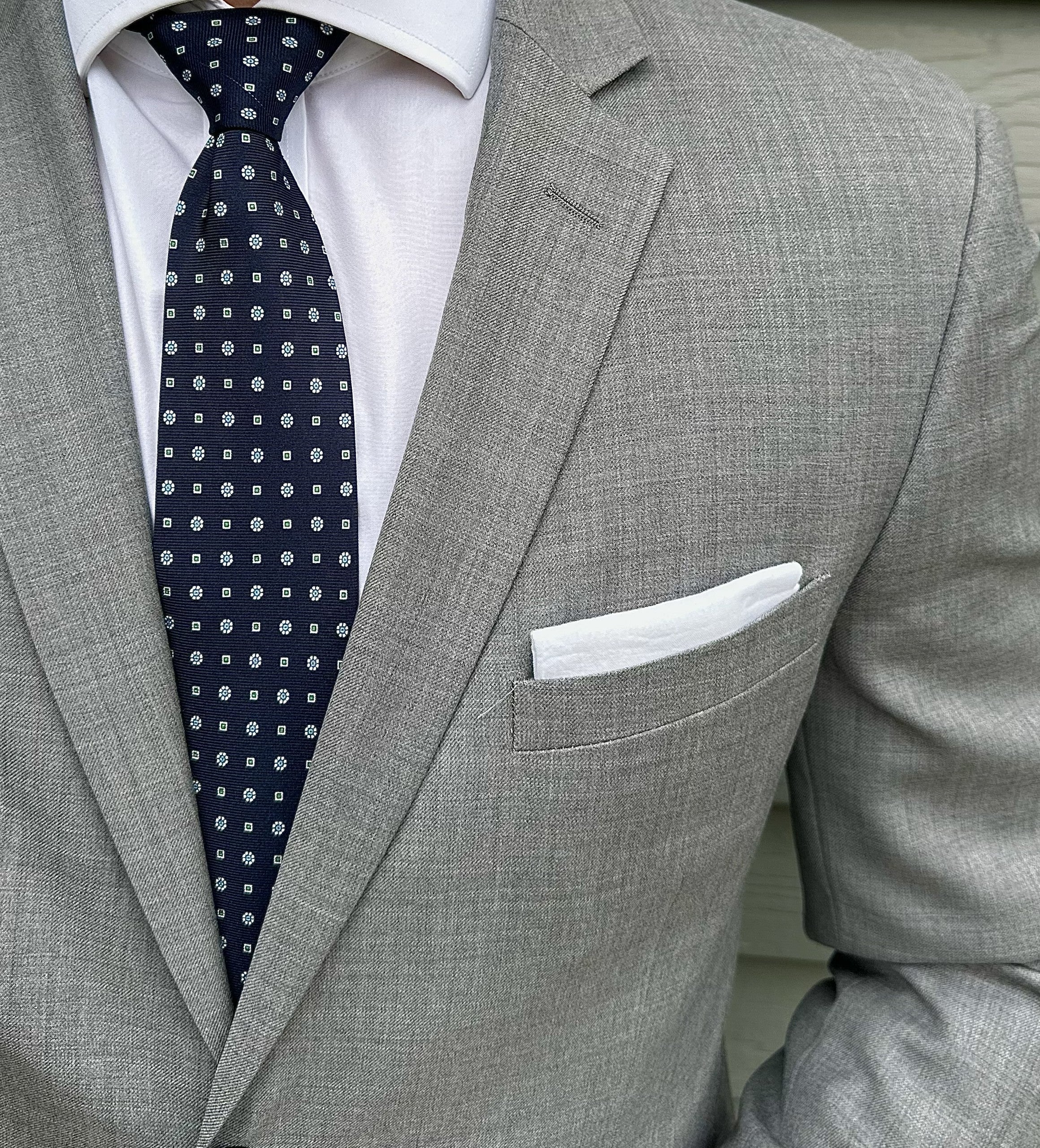 Navy silk necktie with a micro geometric motif, shown in close detail