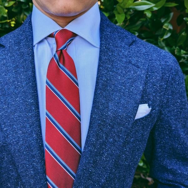 Red striped silk necktie photographed flat, diagonal stripe repeat