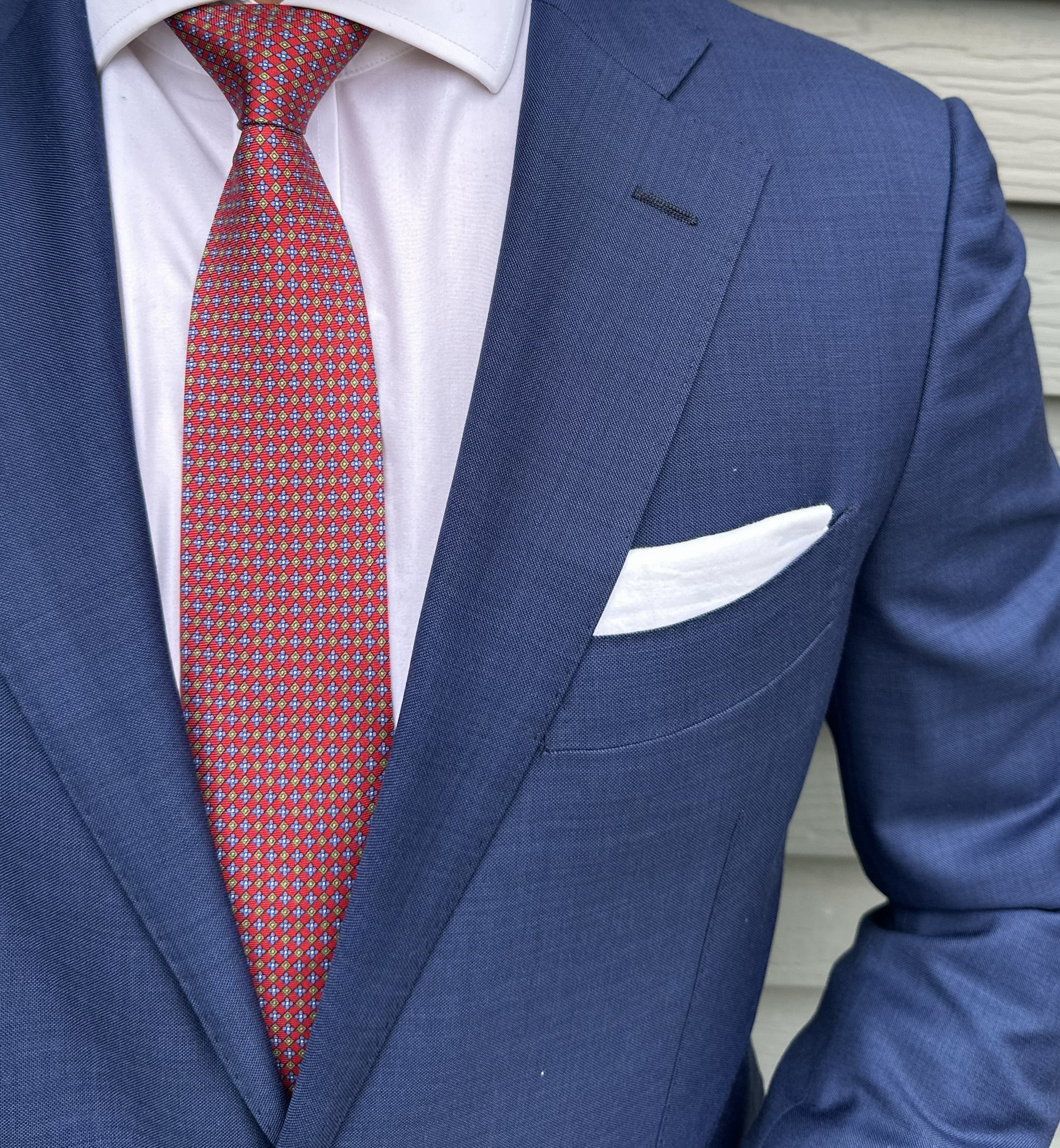 Red printed foulard silk necktie shown flat, motif repeat in view