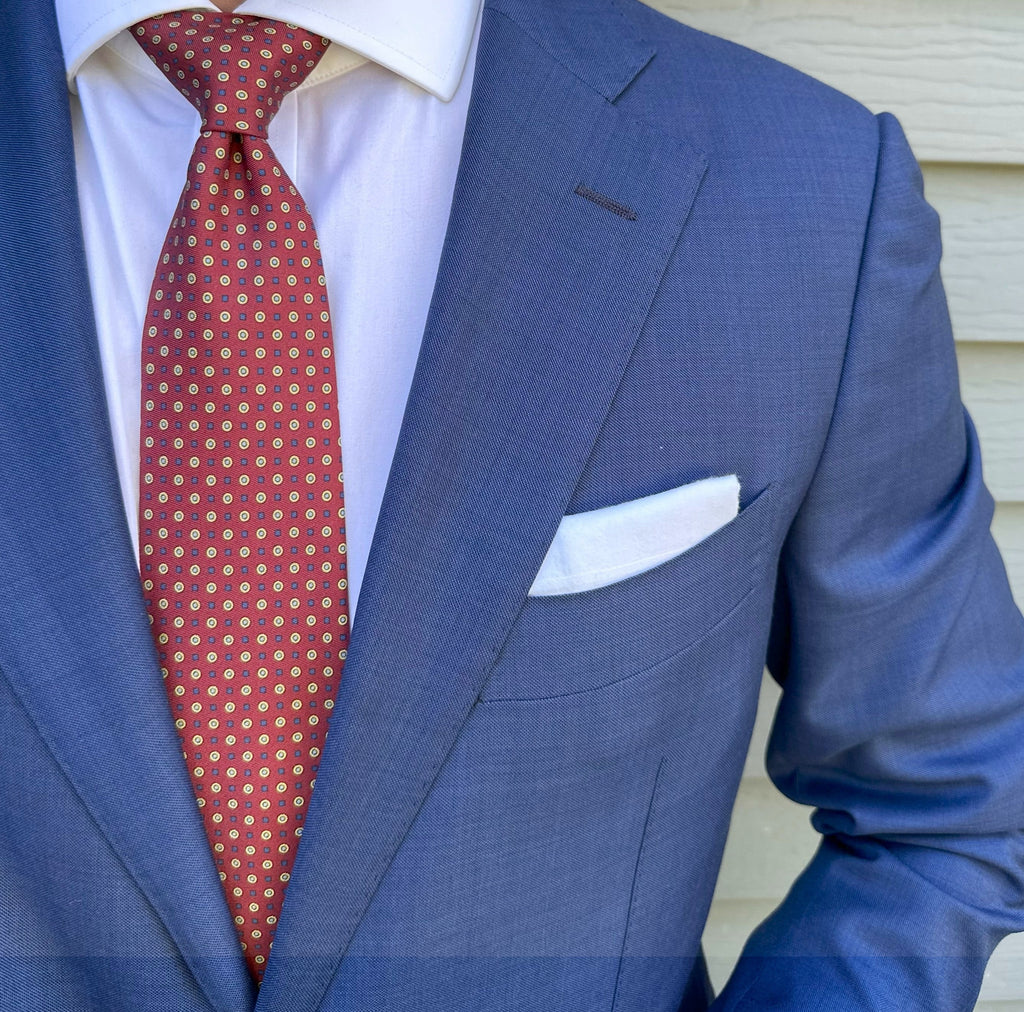 Crimson silk necktie with a micro geometric weave, shown close up
