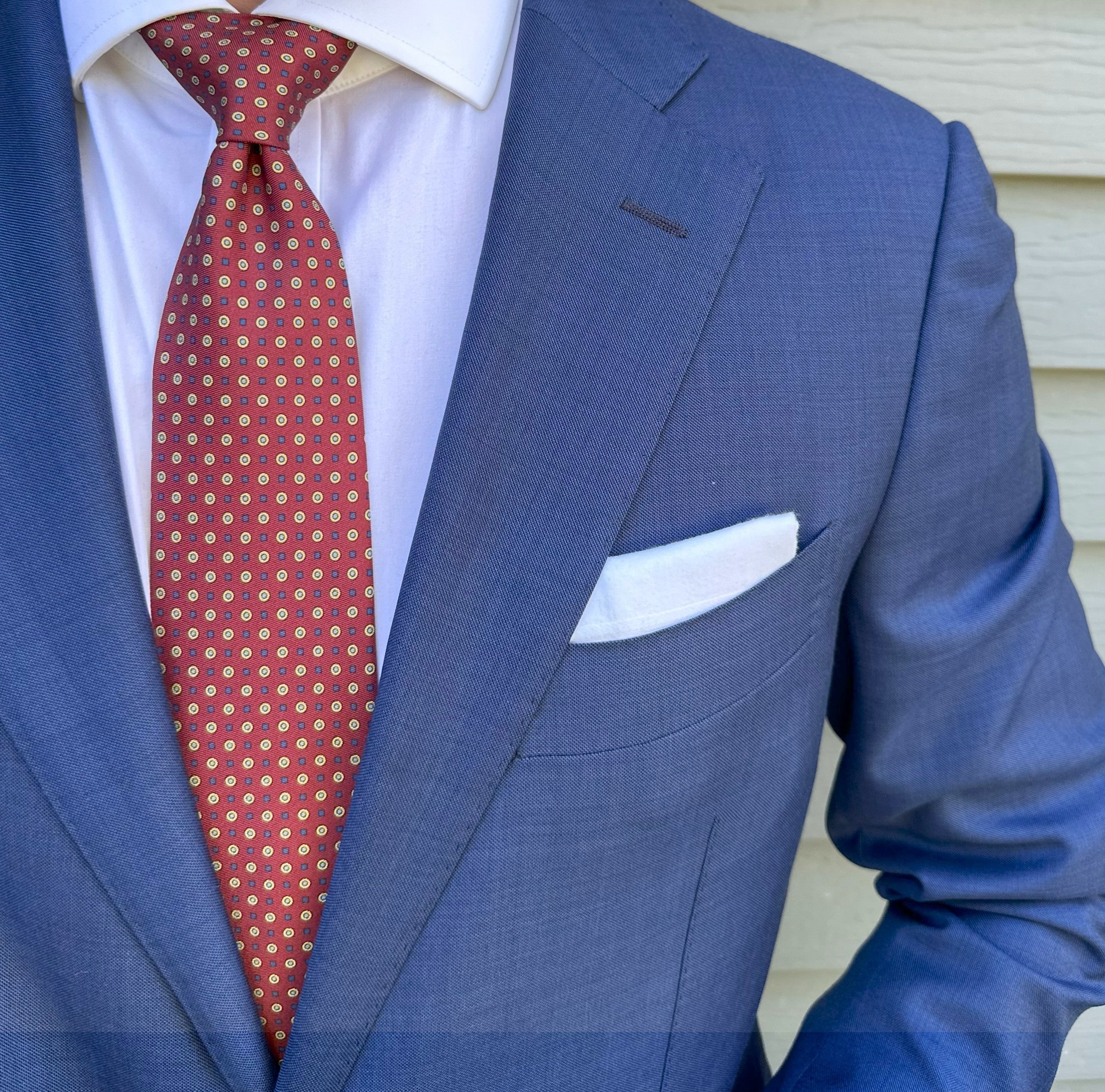 Crimson silk necktie with a micro geometric weave, shown close up