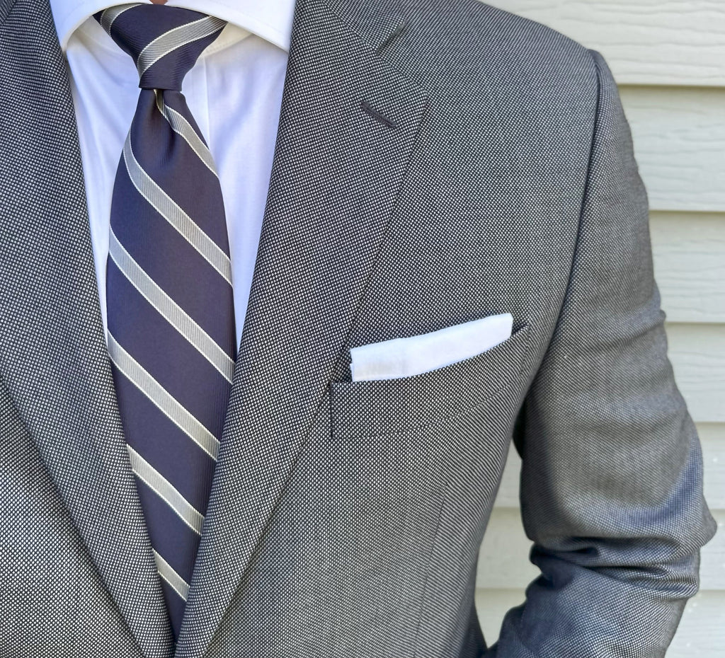 Navy striped silk necktie laid flat with the stripe repeat in view
