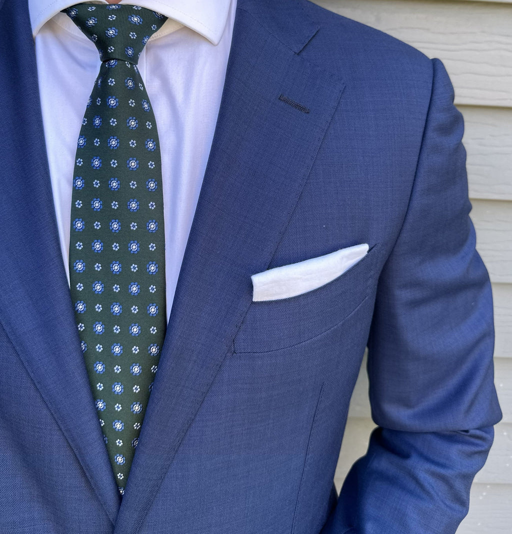 Dark green foulard silk necktie with a small repeating motif, flat